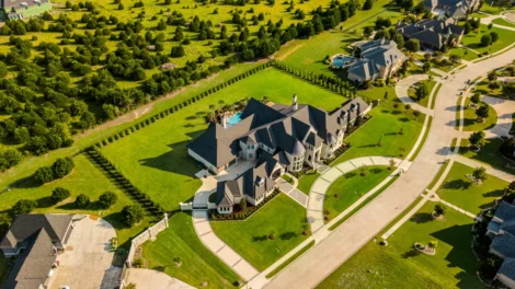 Image of a drone aerial shot of a luxury residential property and surrounding neighborhood
