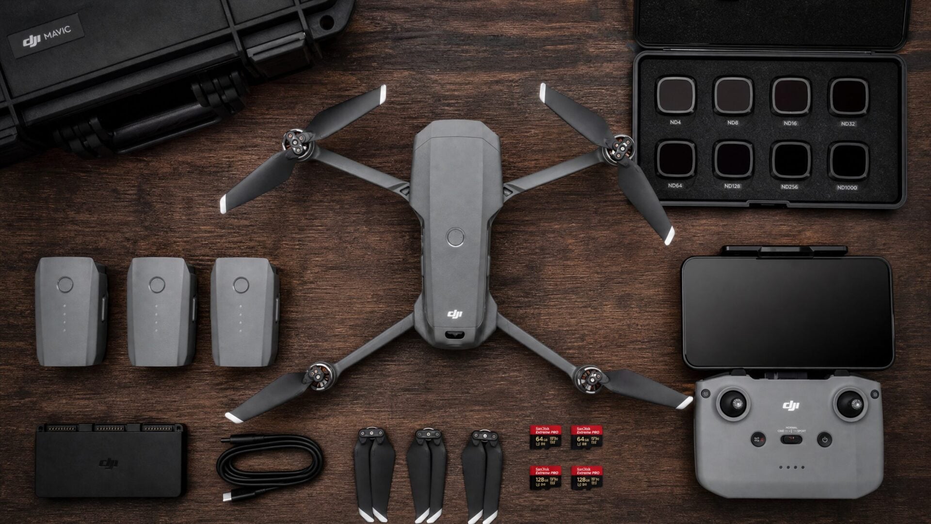 Professional drone videography equipment flat lay including drone, ND filters, batteries, and controller